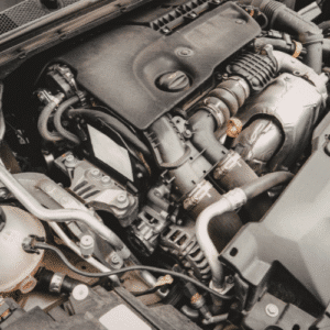 Close-up view of a car engine, showcasing various metal parts, hoses, and components under the hood—highlighting the smartest move when selling a junk car: salvaging quality used car parts.